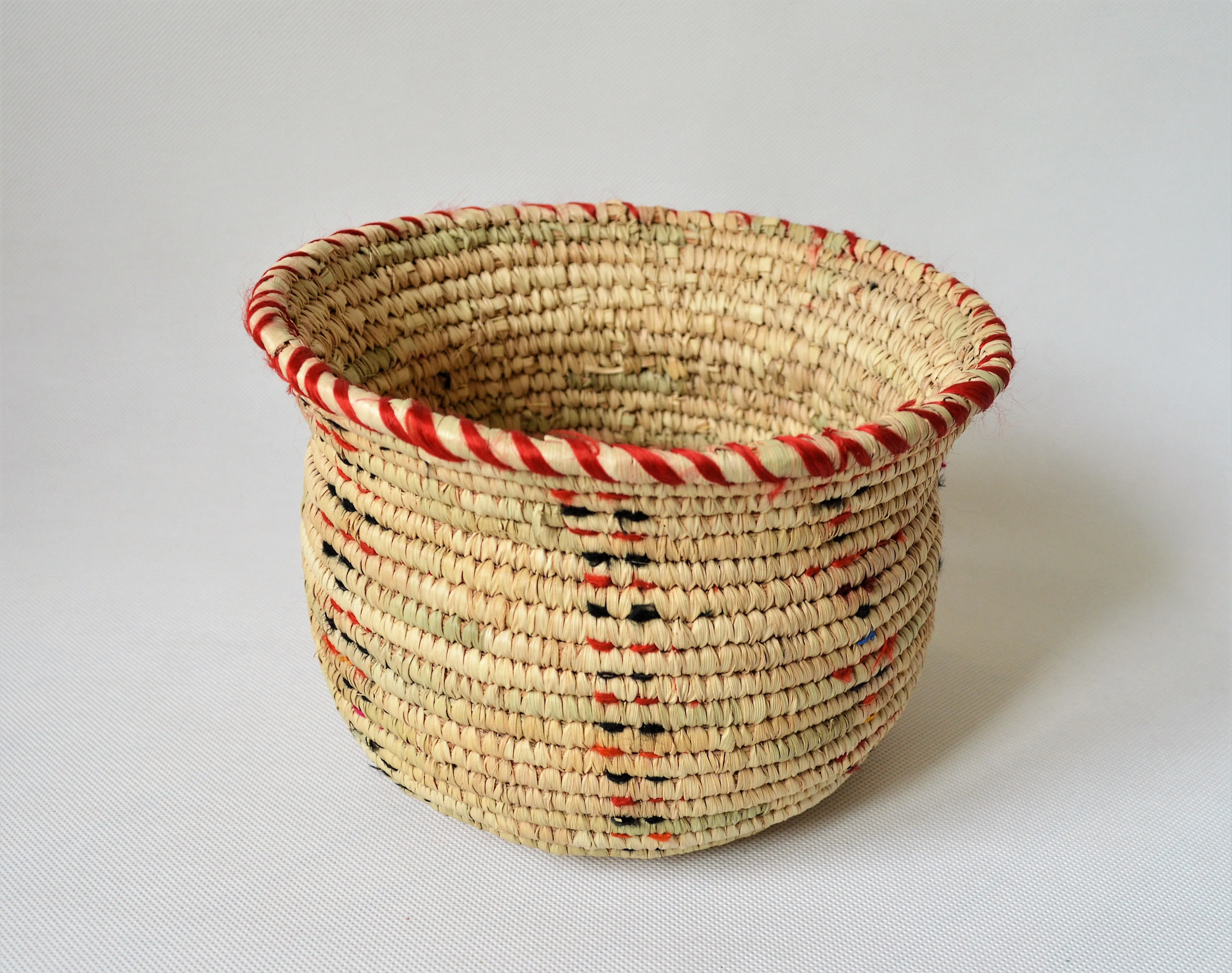 Wide woven bowl decorated with red and black fabric