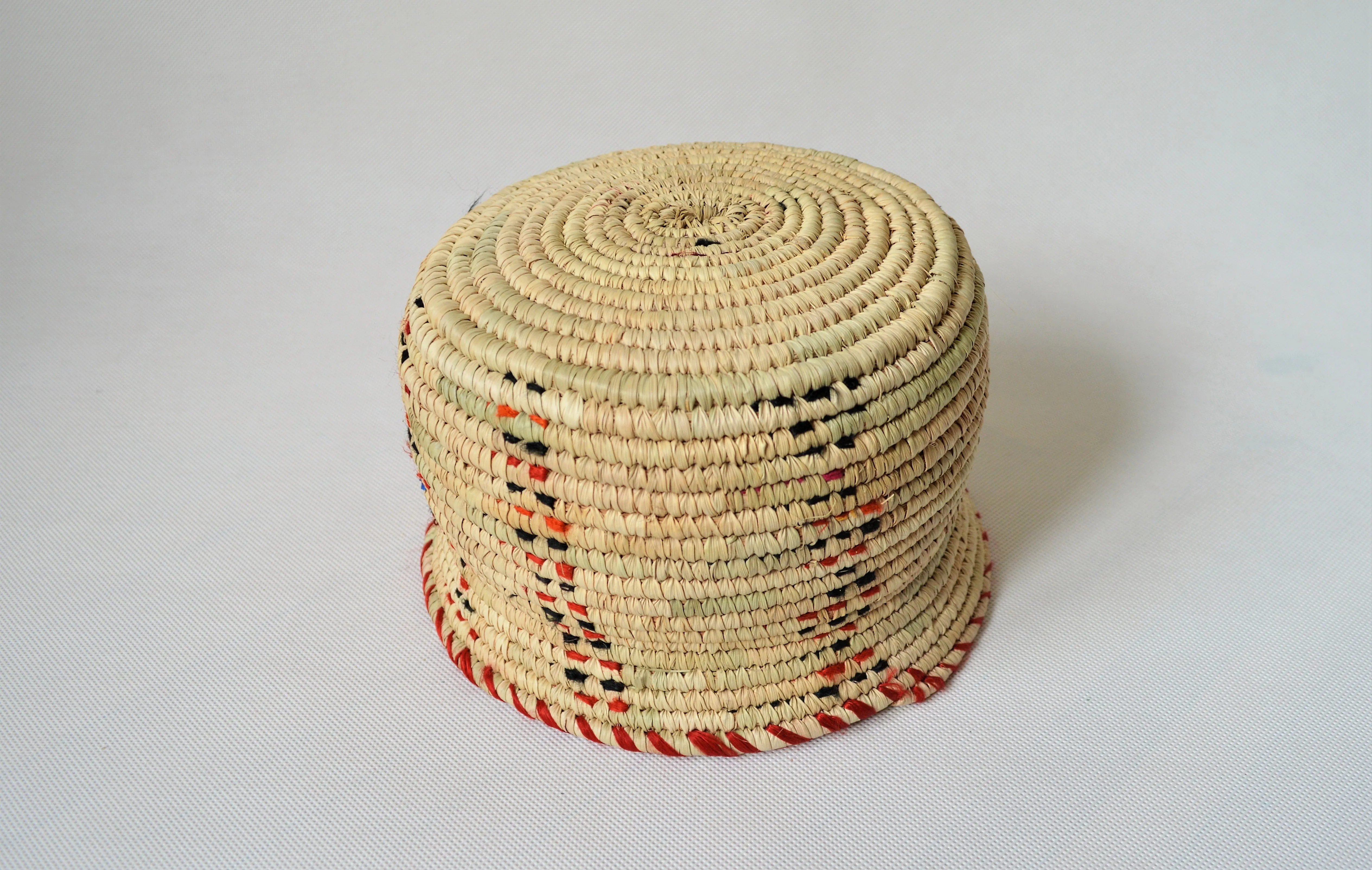 Wide woven bowl decorated with red and black fabric